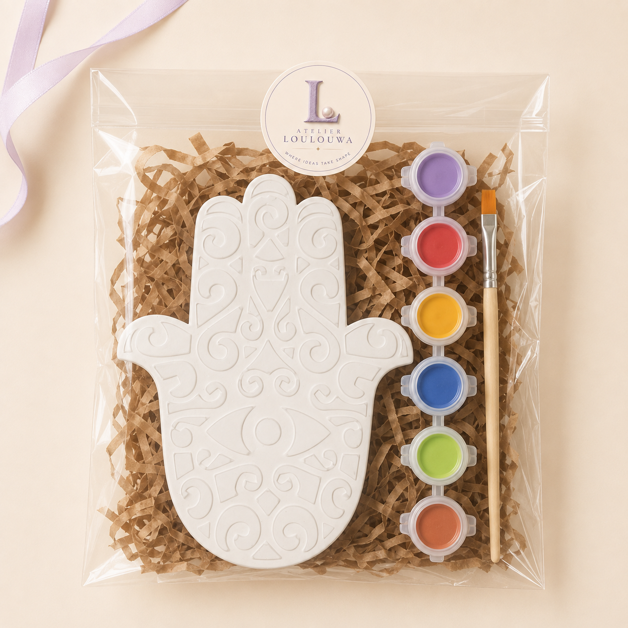 Mandala kit as it arrives: gypsum pieces, paints and a brush